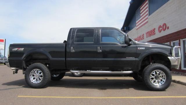 Black lifted pickup truck parked in a lot, side view.