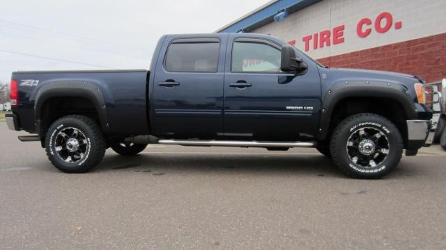Black pickup truck parked outside a tire shop building