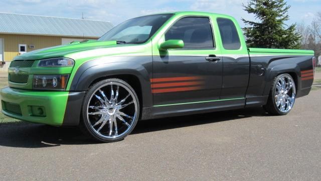 Bright green and black custom pickup truck with red side stripes parked outdoors