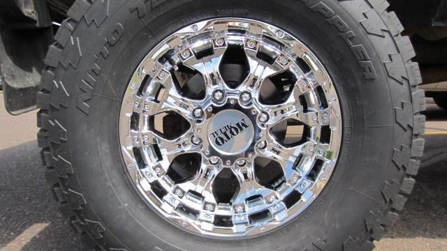 Chrome truck wheel with rugged off-road tire on pavement