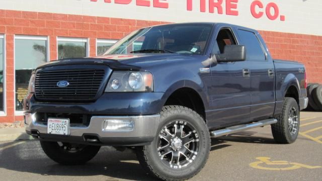Blue Ford pickup truck parked outside a tire shop