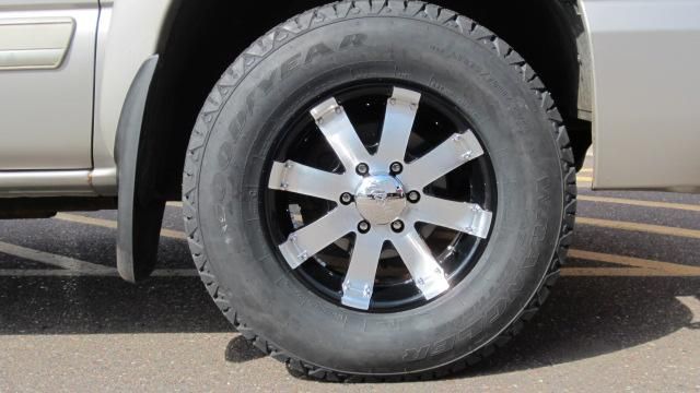 Flat tire on a silver SUV with black-and-chrome wheel, parked on pavement.