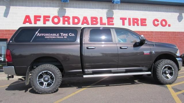 Black lifted pickup truck parked outside Affordable Tire Co. storefront