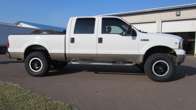 White lifted pickup truck parked outside a garage on a sunny day