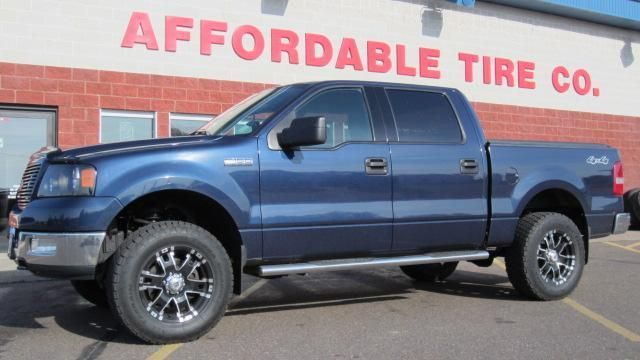 Blue pickup truck parked outside Affordable Tire Co.