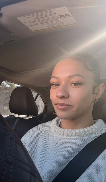Person sitting in a car, wearing a gray sweater and seatbelt, with sunlight streaming in. Person sitting in a car, wearing a gray sweater and seatbelt, with sunlight streaming in.