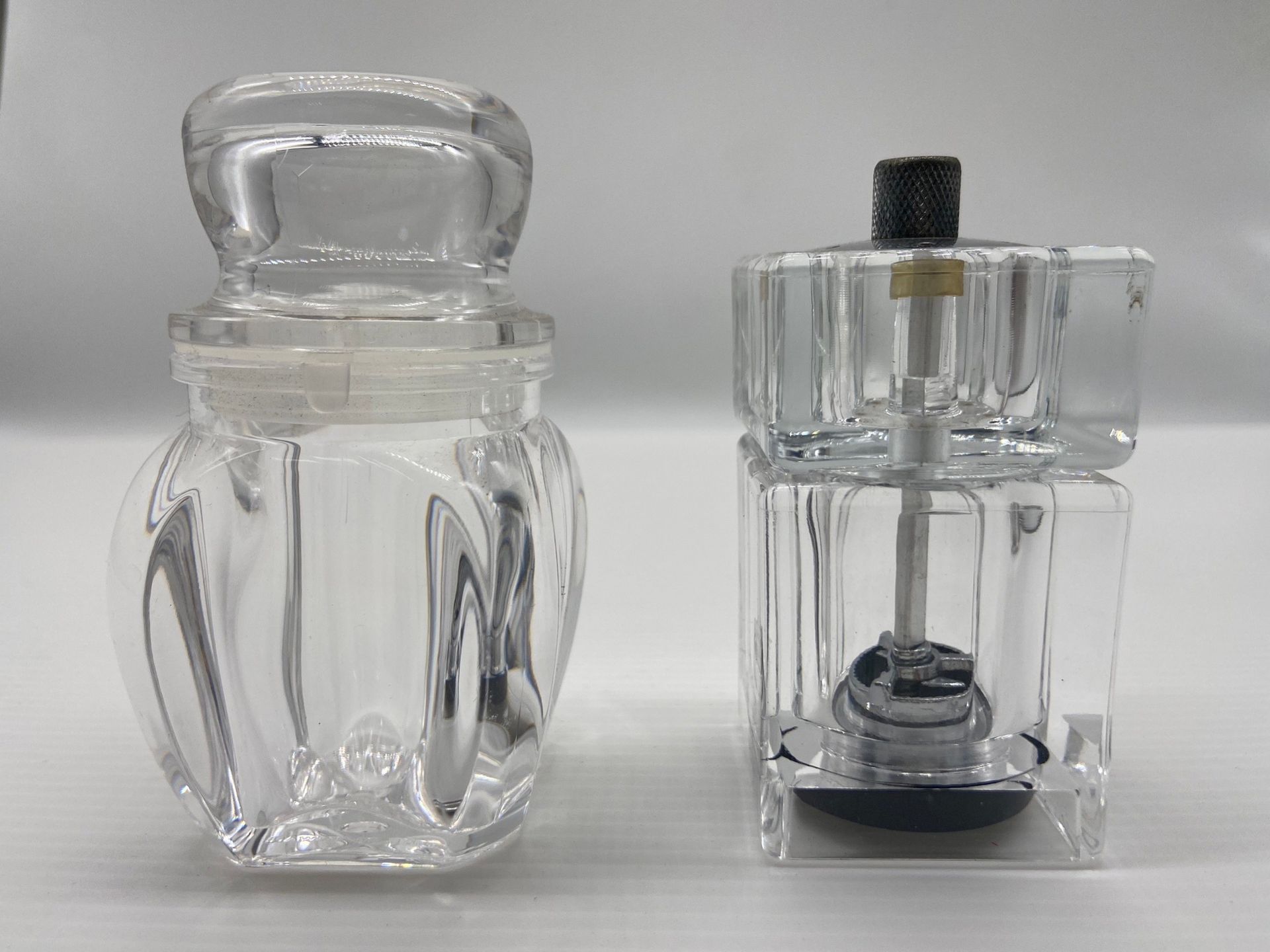 白色表面上擺放著透明鹽瓶和胡椒研磨器、塑膠射出。