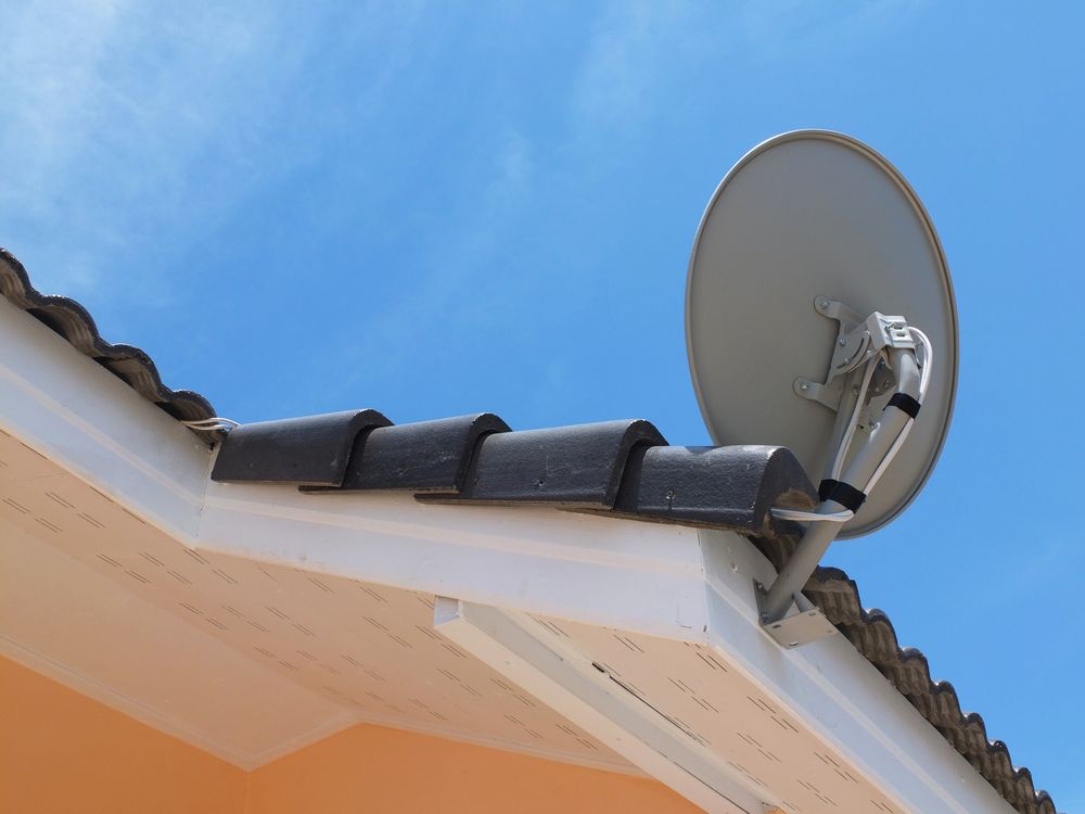 A Satellite Dish Is Mounted On The Roof Of A House — Craig's TV/Antenna Services In Maryland, NSW