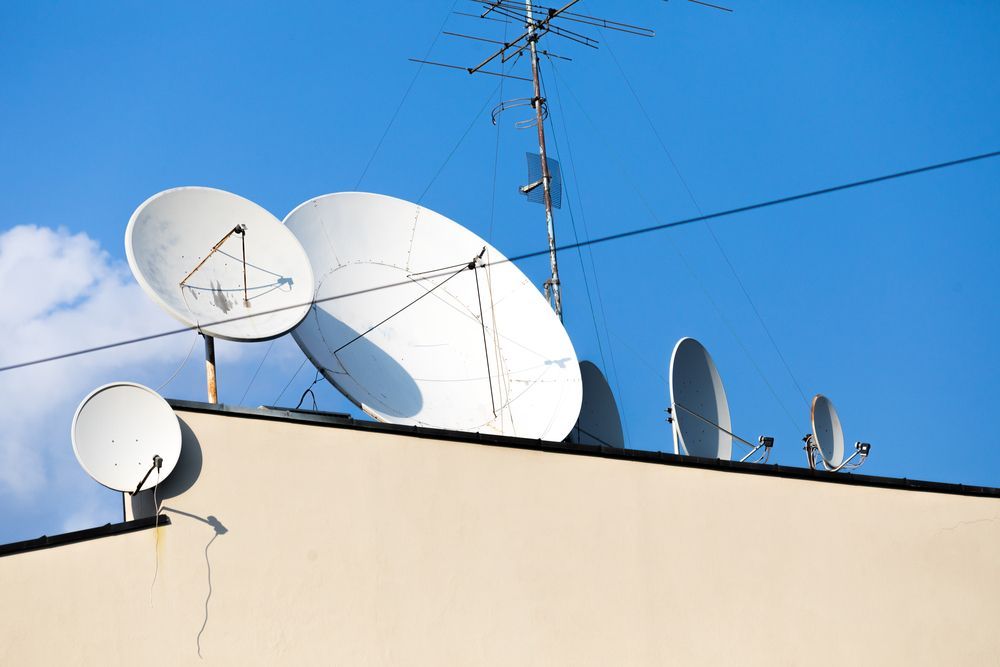 A Bunch Of Satellite Dishes On Top Of A Building — Craig's TV/Antenna Services In Merewether, NSW