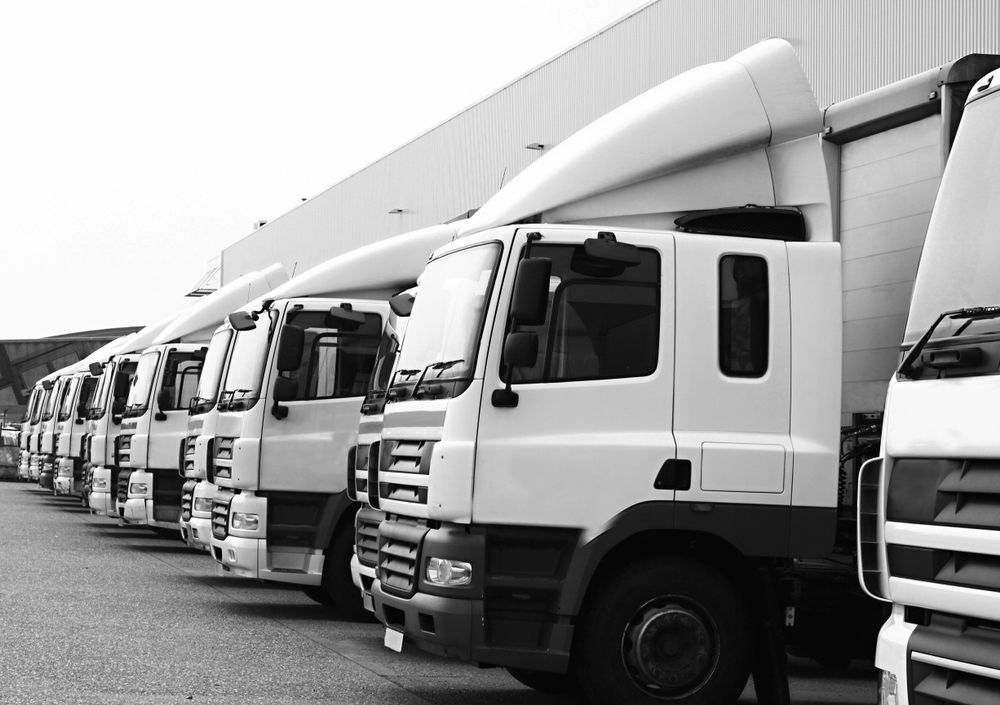 A Line of White Semi-Trucks Parked Near a Building — Aust. Advanced Trailer Sales & Service in Katherine, NT