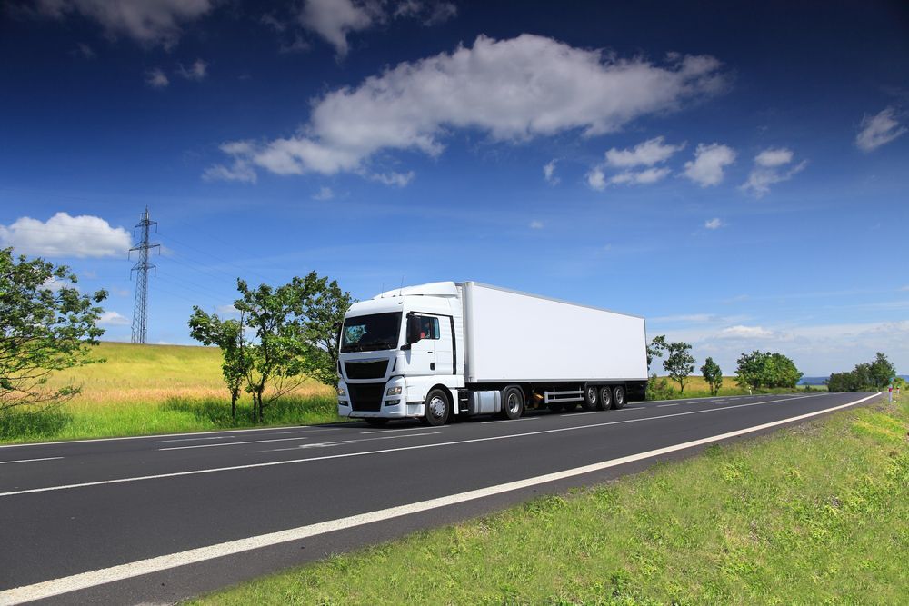 A White Semi-Truck on An Asphalt Road — Aust. Advanced Trailer Sales & Service in Berrimah, NT