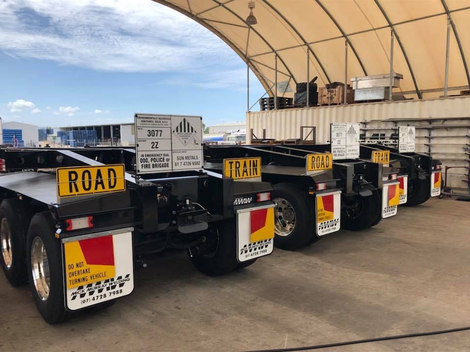 A Row of Black Truck Trailers with Reflective Signs — Aust. Advanced Trailer Sales & Service in Berrimah, NT