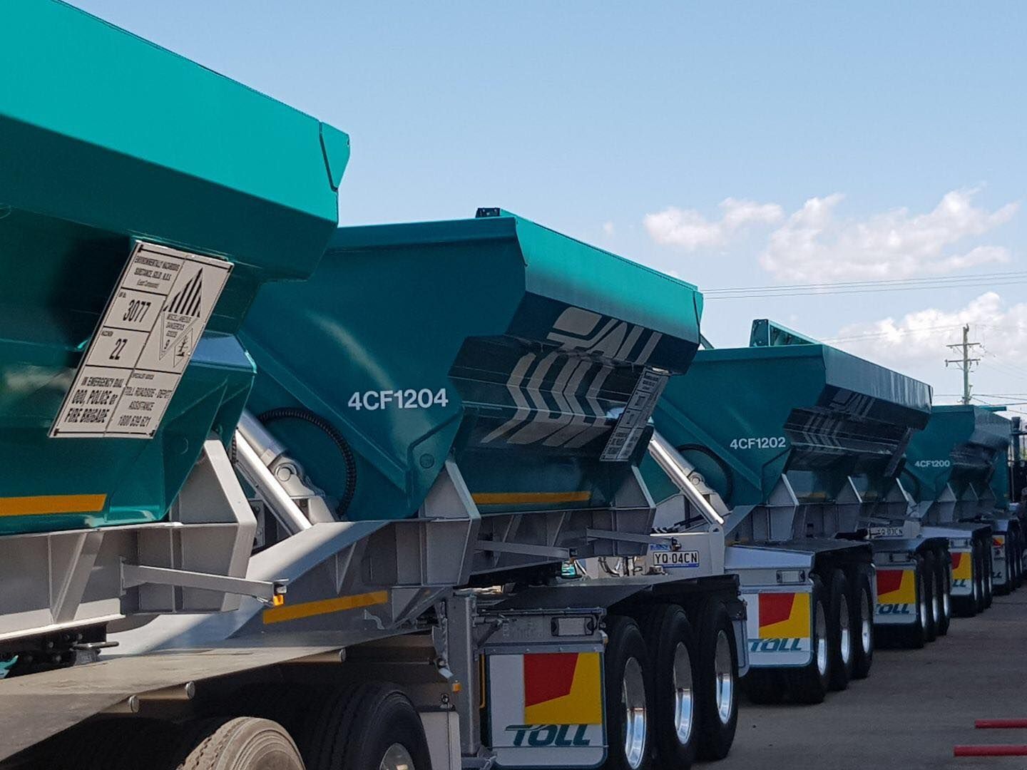 A Line of Teal-Colored Truck Trailers with Raised Beds — Aust. Advanced Trailer Sales & Service in Berrimah, NT