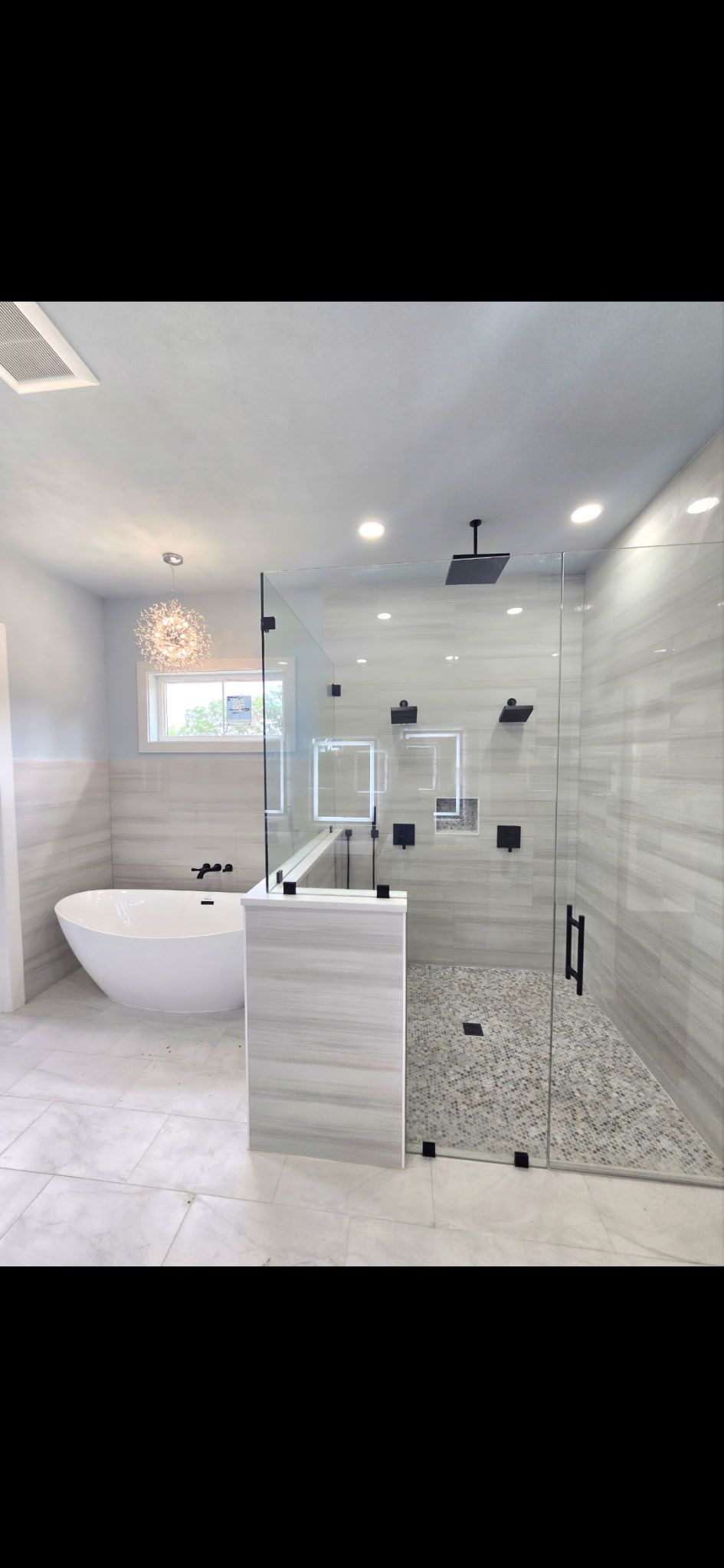 Modern bathroom with white walls, a standalone tub, and a glass shower.