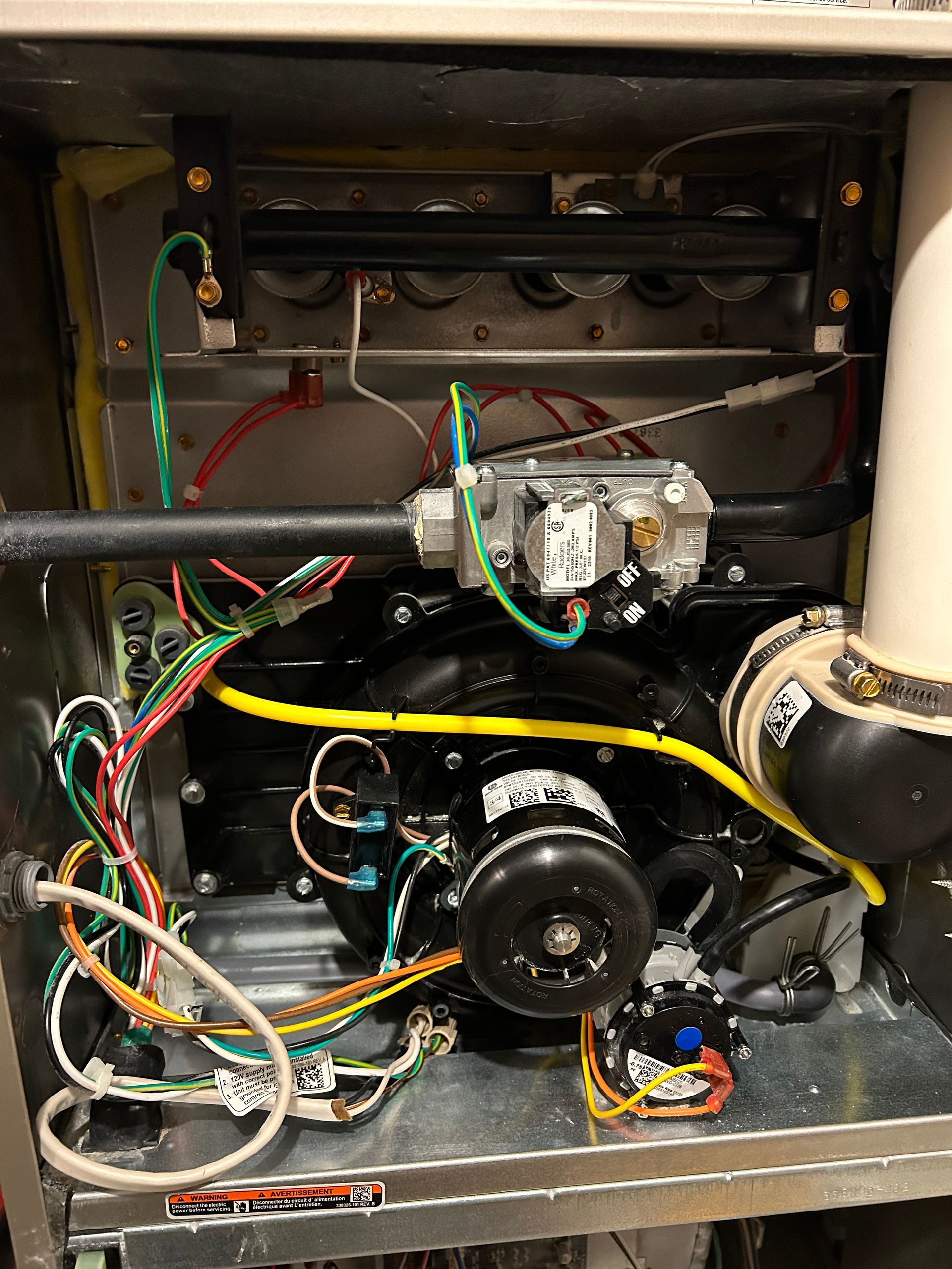 The inside of a heater with a lot of wires coming out of it.