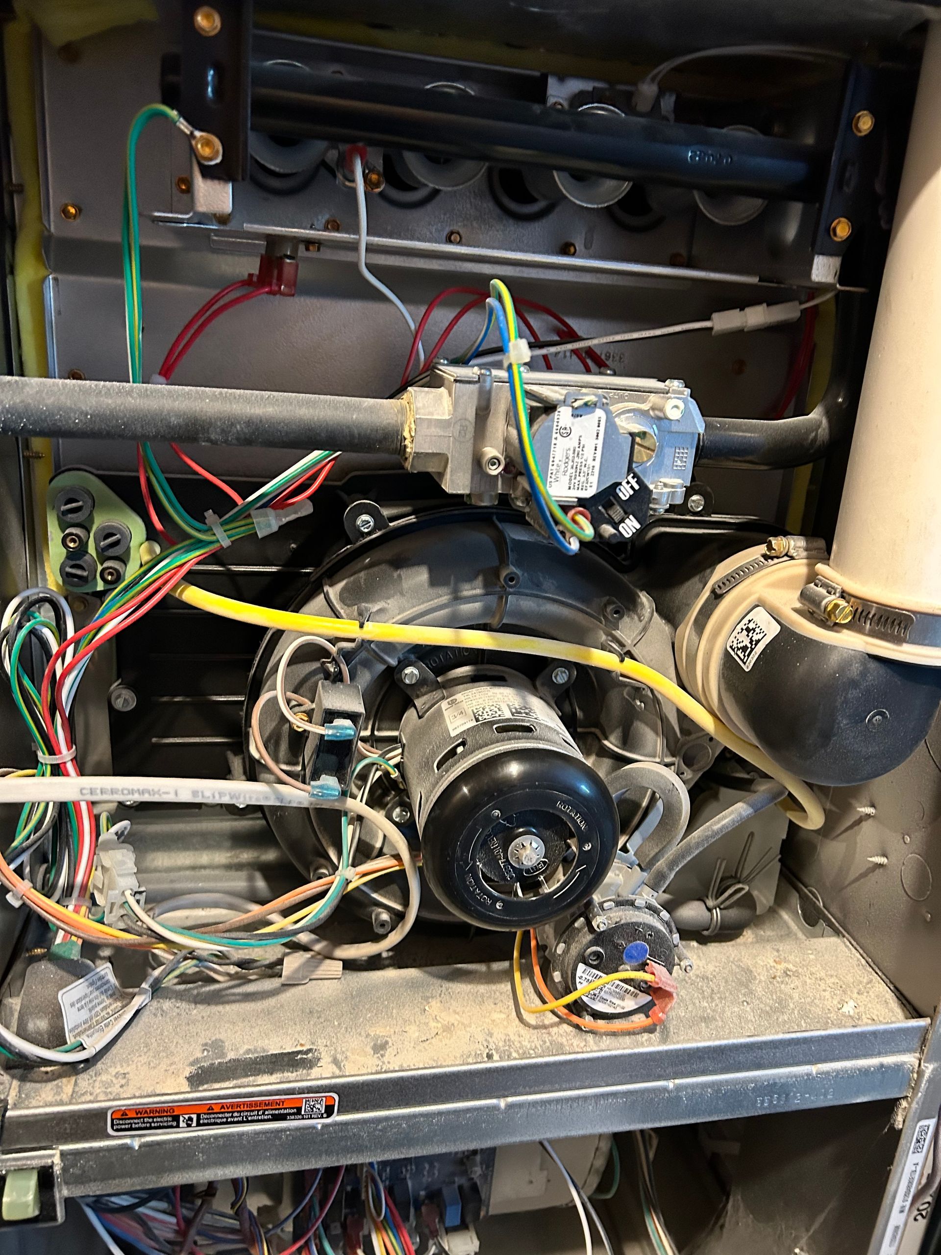 The inside of a heater with a lot of wires coming out of it.