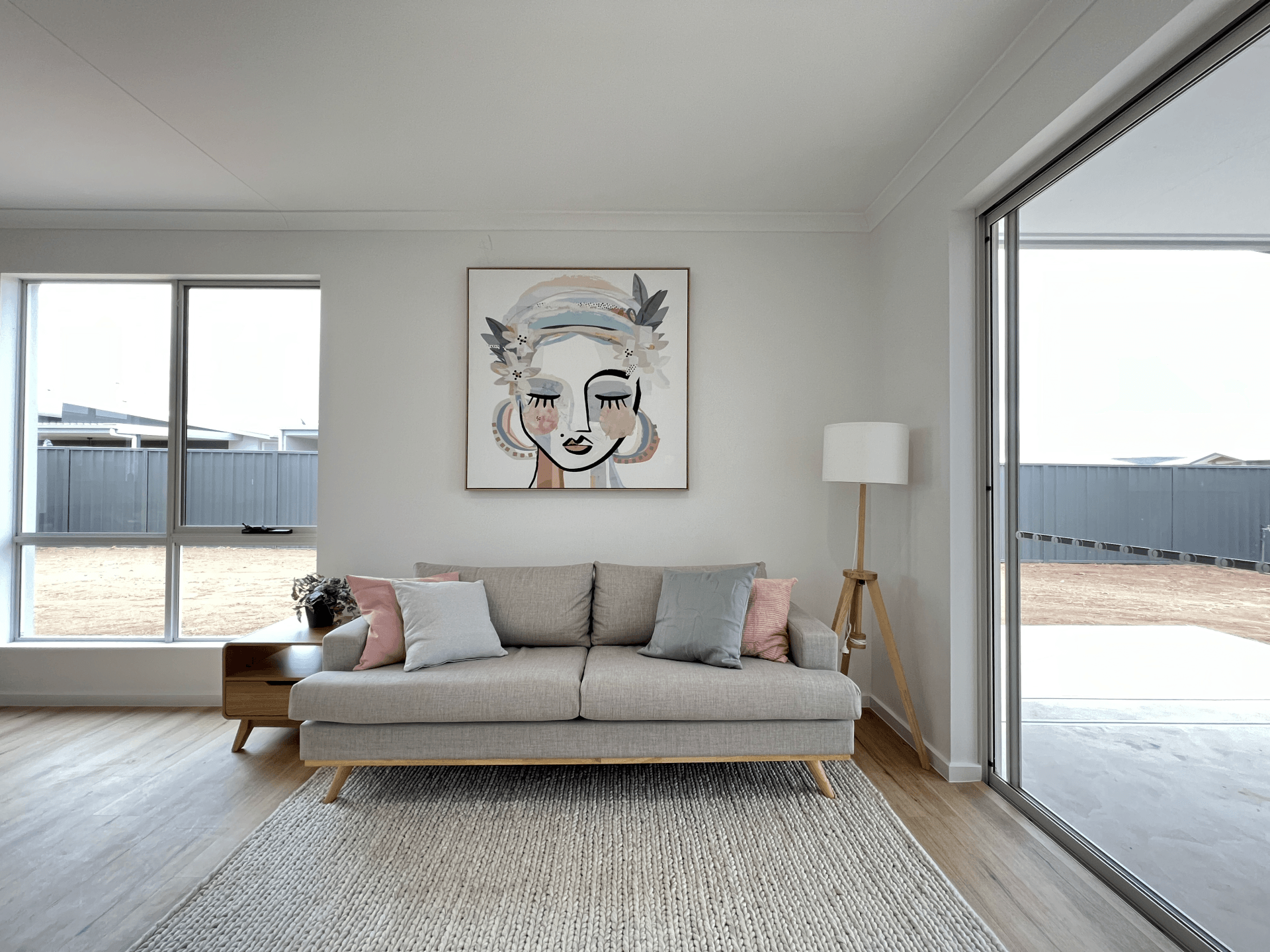 A living room with a couch and a painting on the wall.
