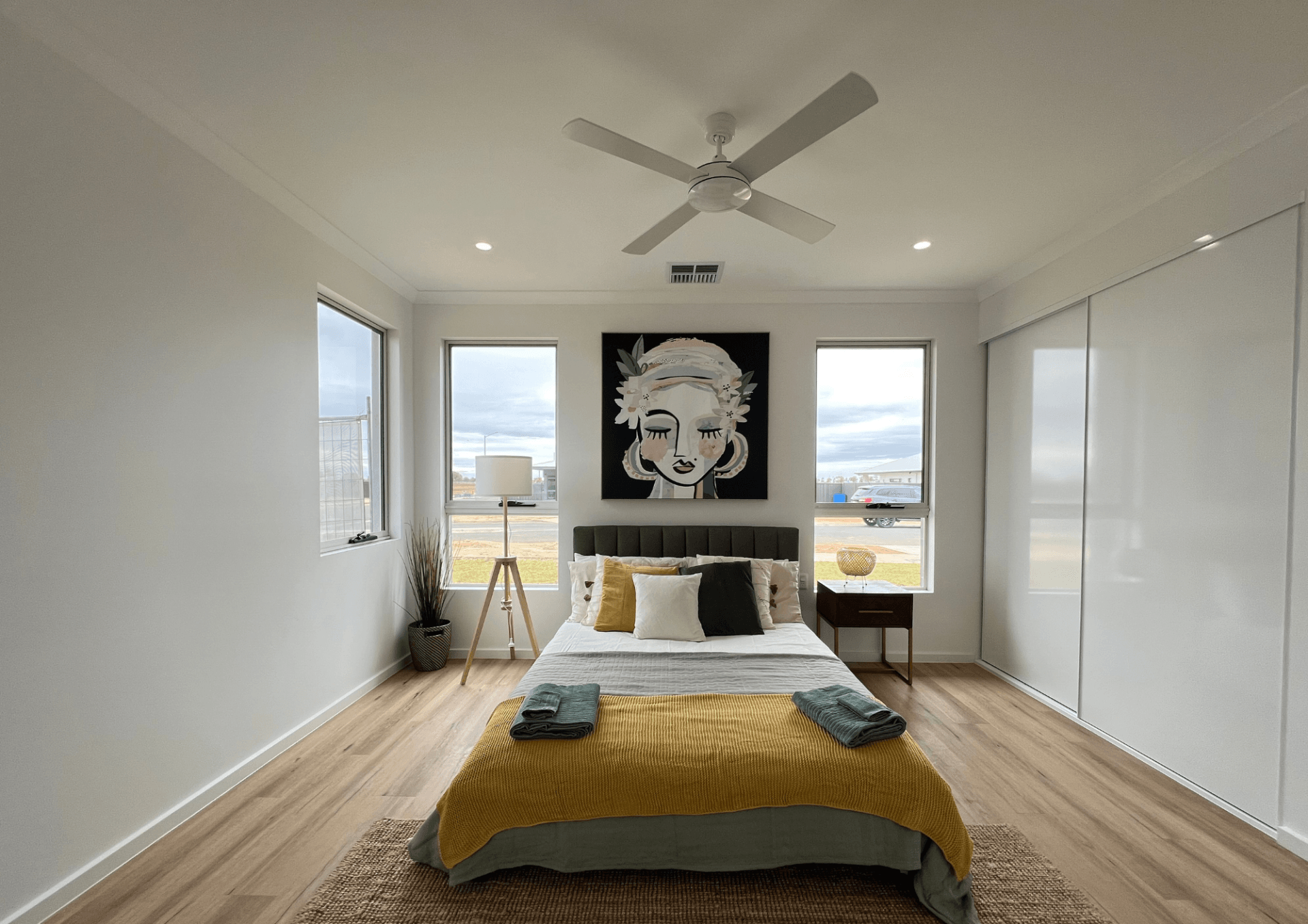 A bedroom with a bed and a ceiling fan.