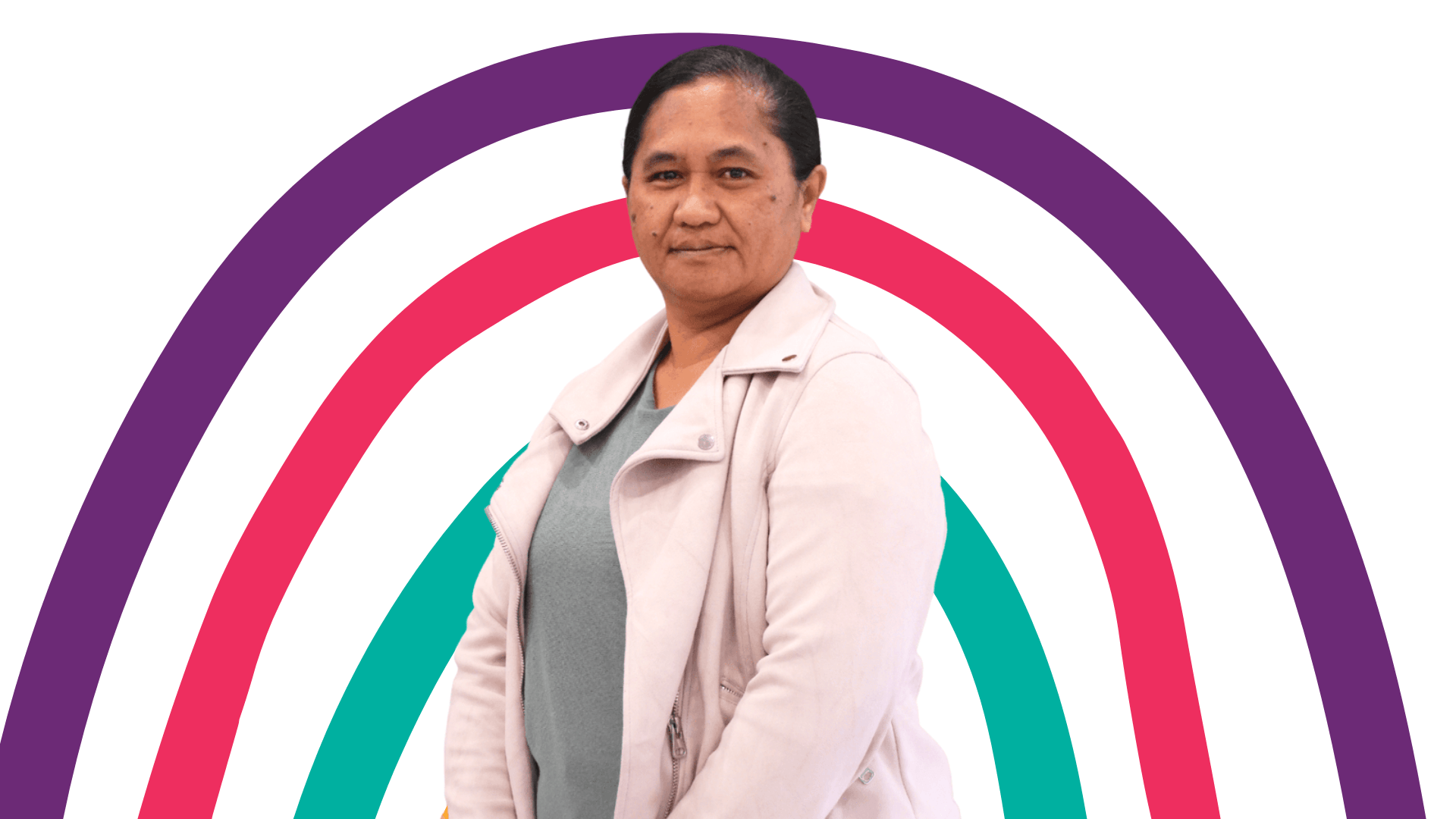A woman is standing in front of a rainbow.