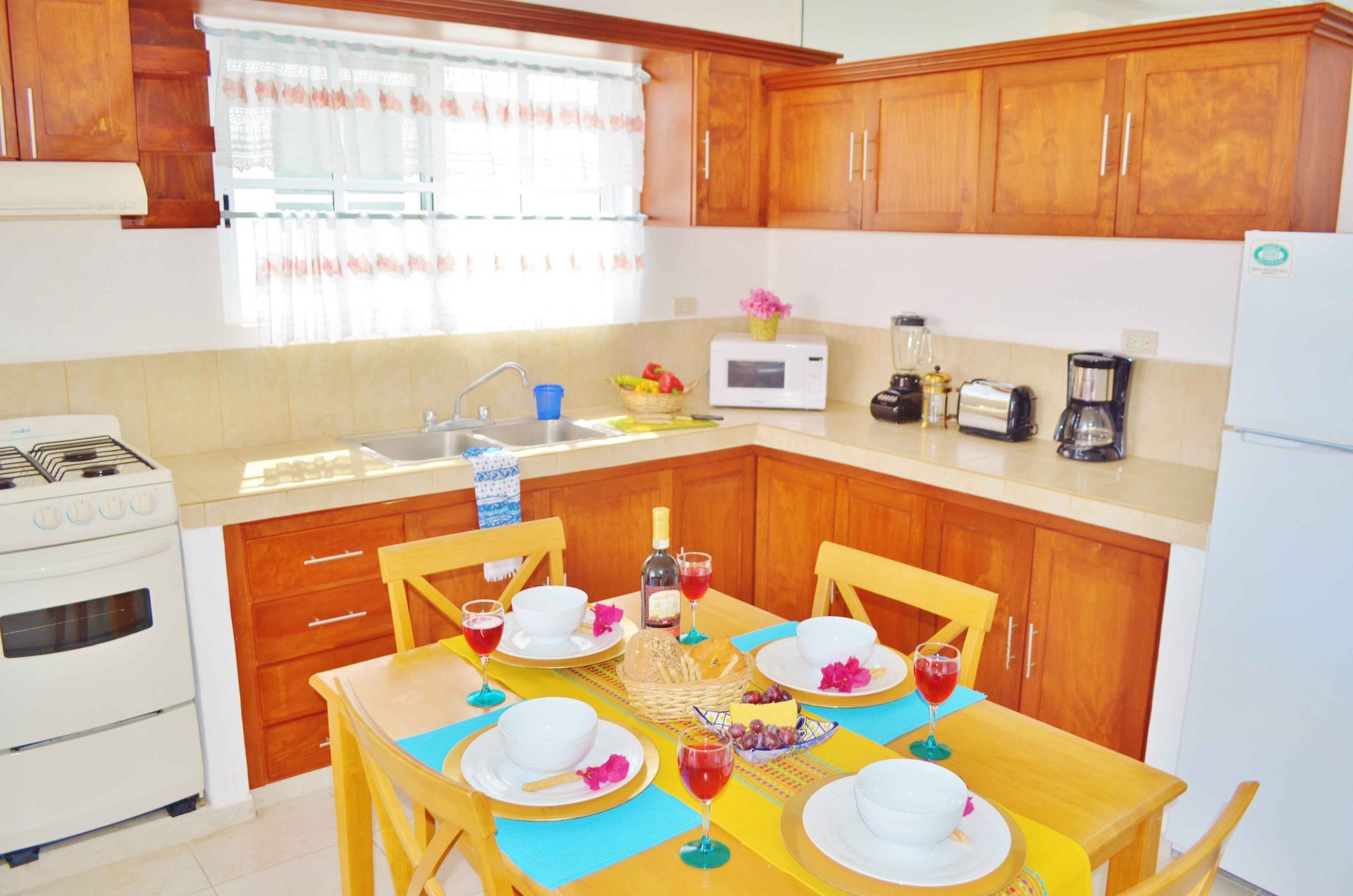 Cocina con armarios de madera, mesa de comedor puesta para cuatro personas.
