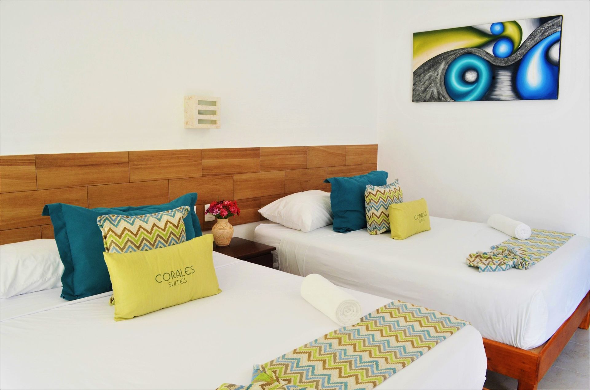 Habitación de hotel con dos camas, ropa de cama blanca.