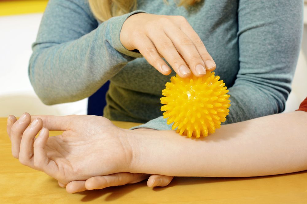 occupational therapy works with hedgehog ball to stimulate motor skills
