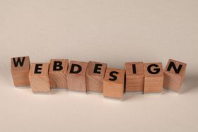 Wooden blocks spelling “WEBDESIGN” on a light background