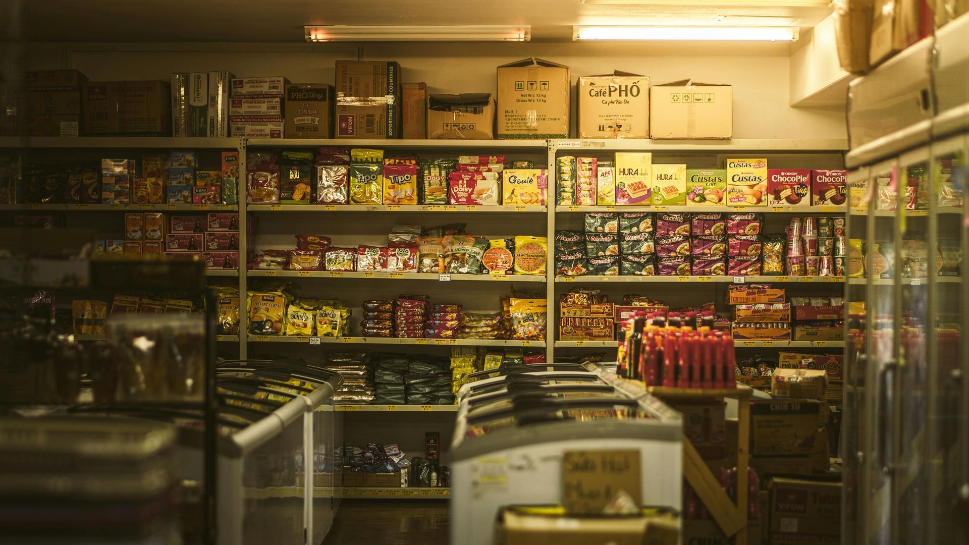 Packed shelves of colorful snacks and drinks inside a small convenience store