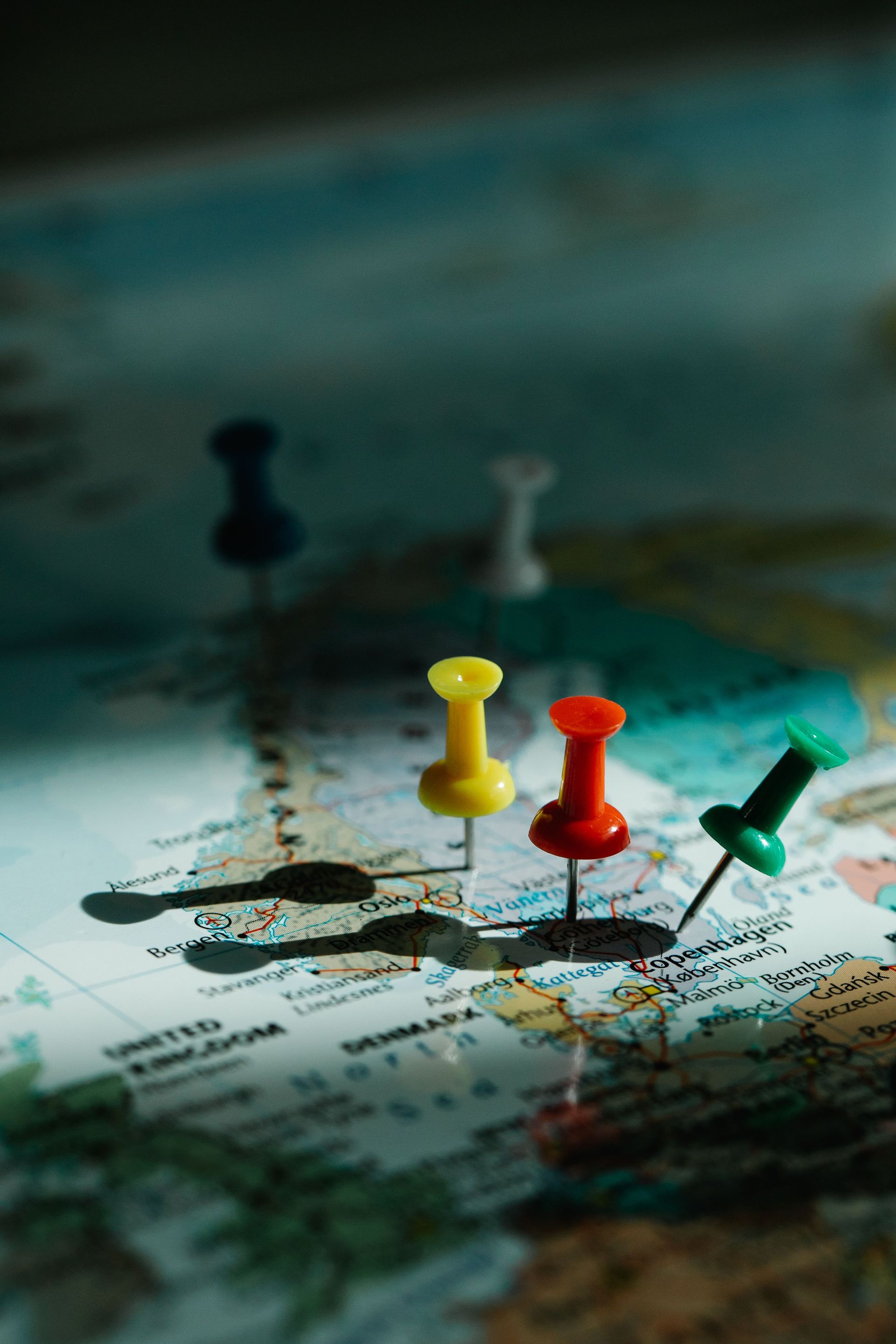 Colorful pushpins on a world map, marking locations and routes
