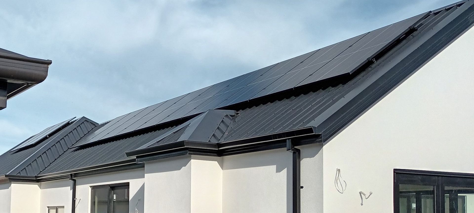 Black solar panels on top of a residential house in Christchurch, New Zealand.