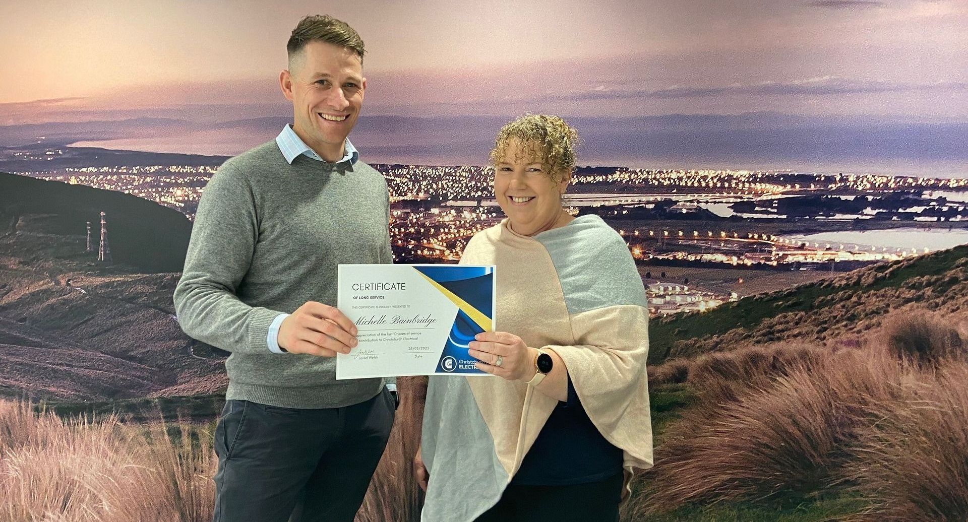 Michelle Bainbridge receiving a 10 year certificate from Jared Welsh