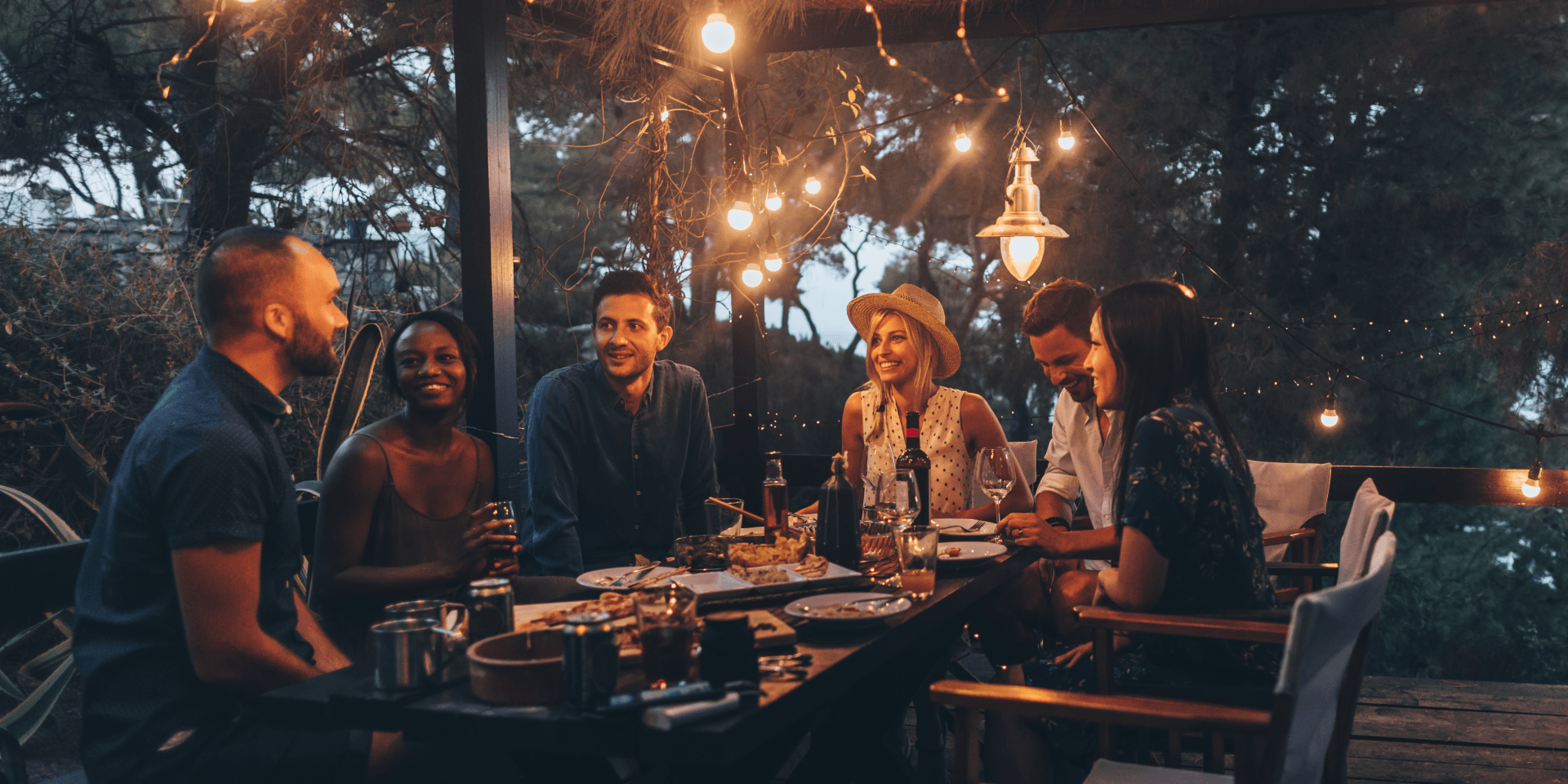 People eating dinner outside with lights