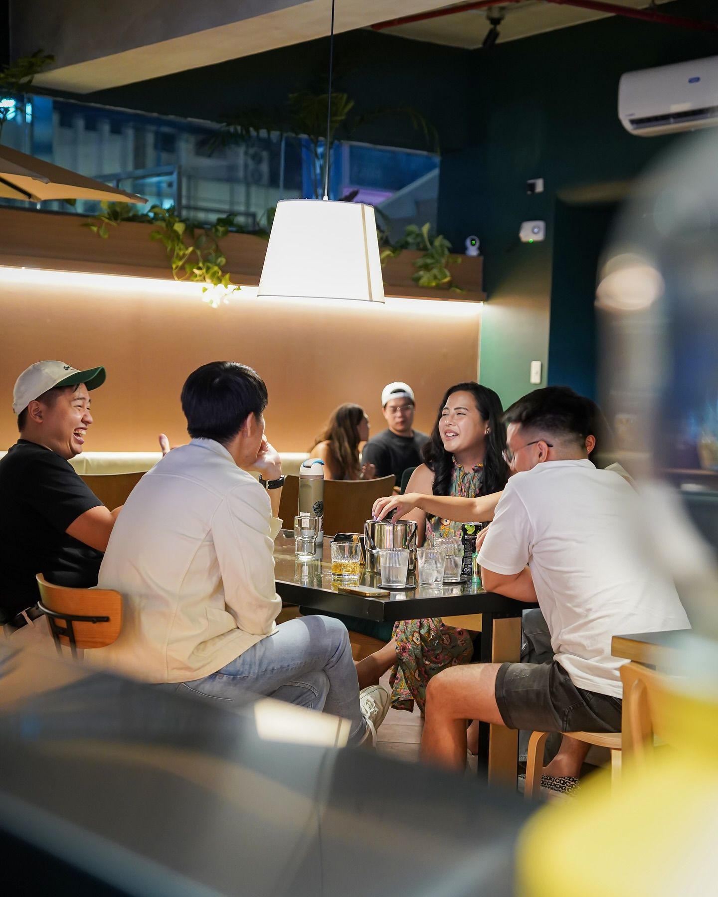 Friends laughing and socializing at The Belamy House bar in Makati