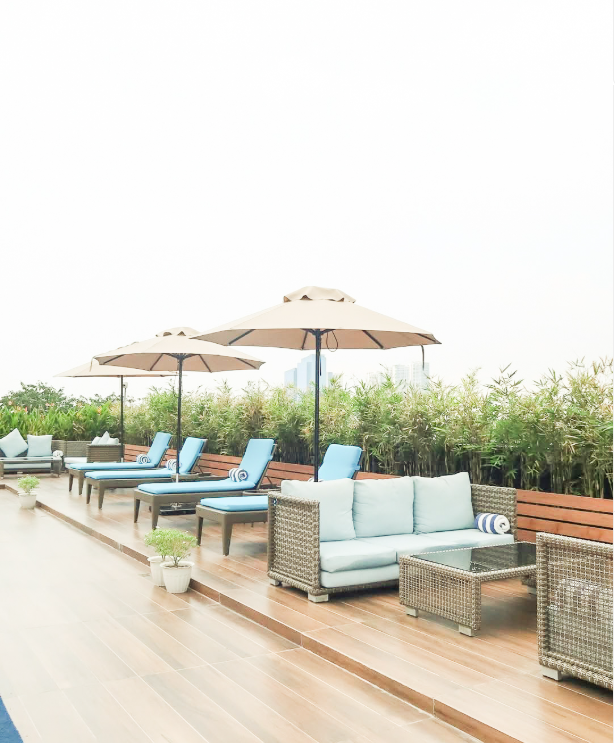 Rooftop pool lounge with wicker sofas and sun loungers at The Belamy House 