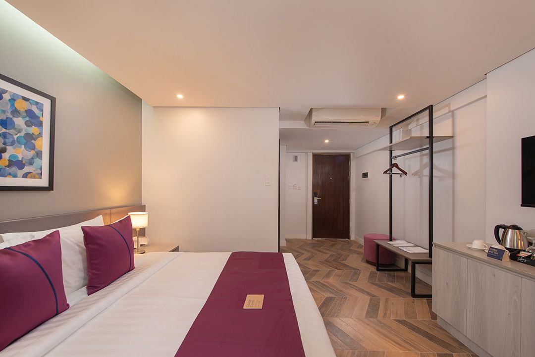 Modern hotel room with king bed and herringbone floor at The Belamy House M