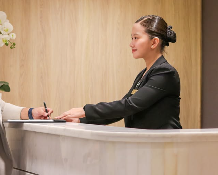 Hotel staff at reception desk checking in guests 