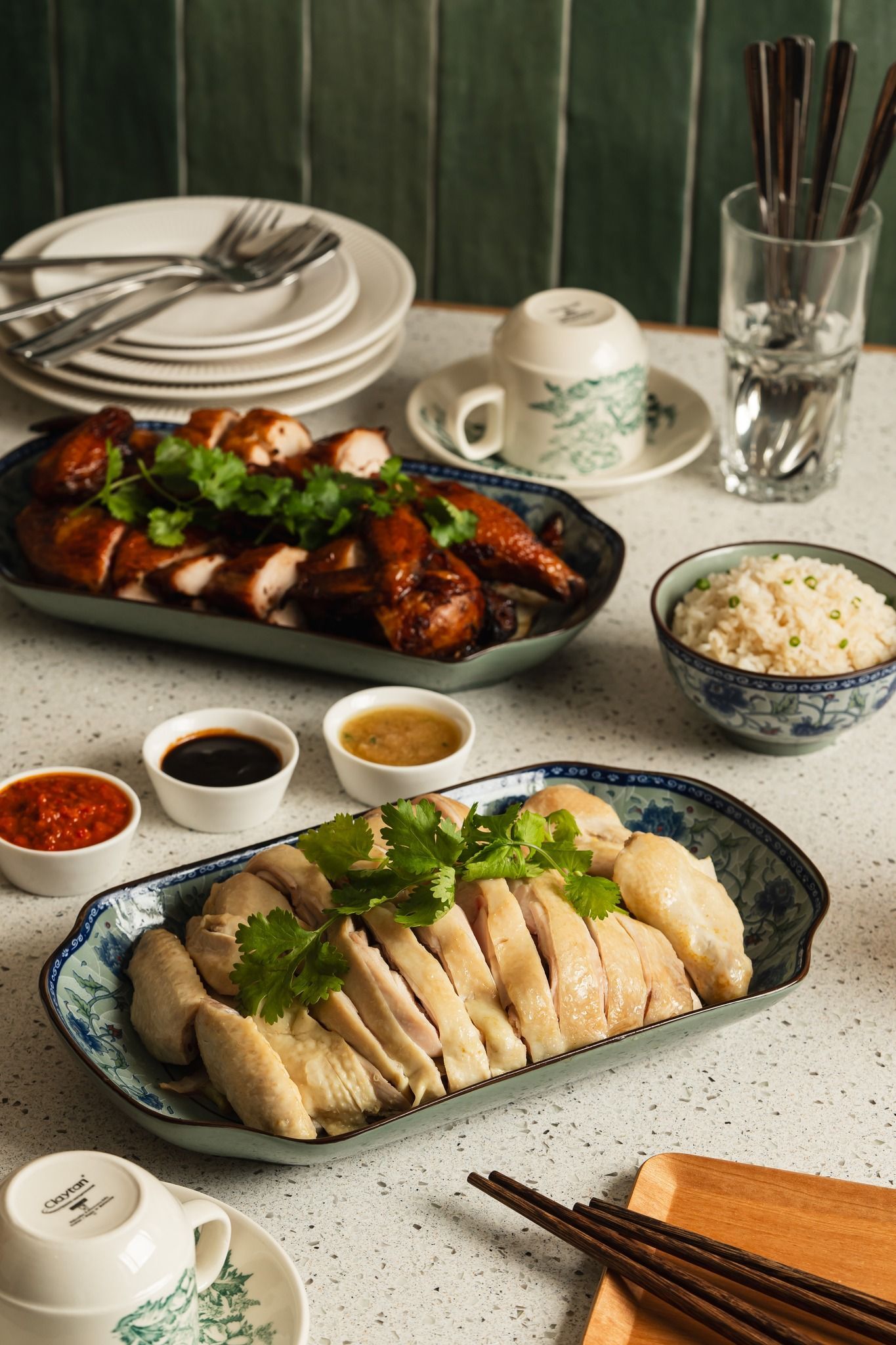 Chicken rice with roasted and steamed chicken, rice, and sauces.