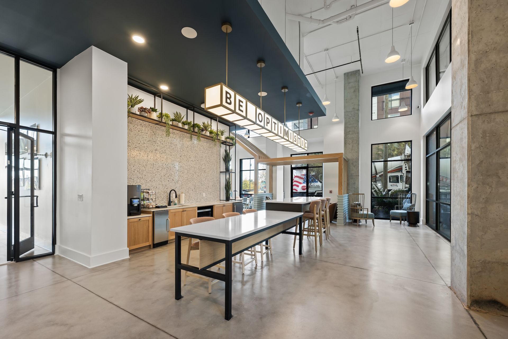 Modern office kitchen with a large island, light wood cabinets, and 