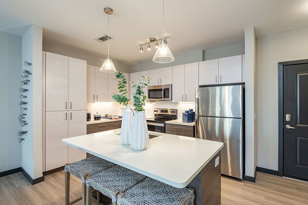 Apartment kitchen with white cabinets.