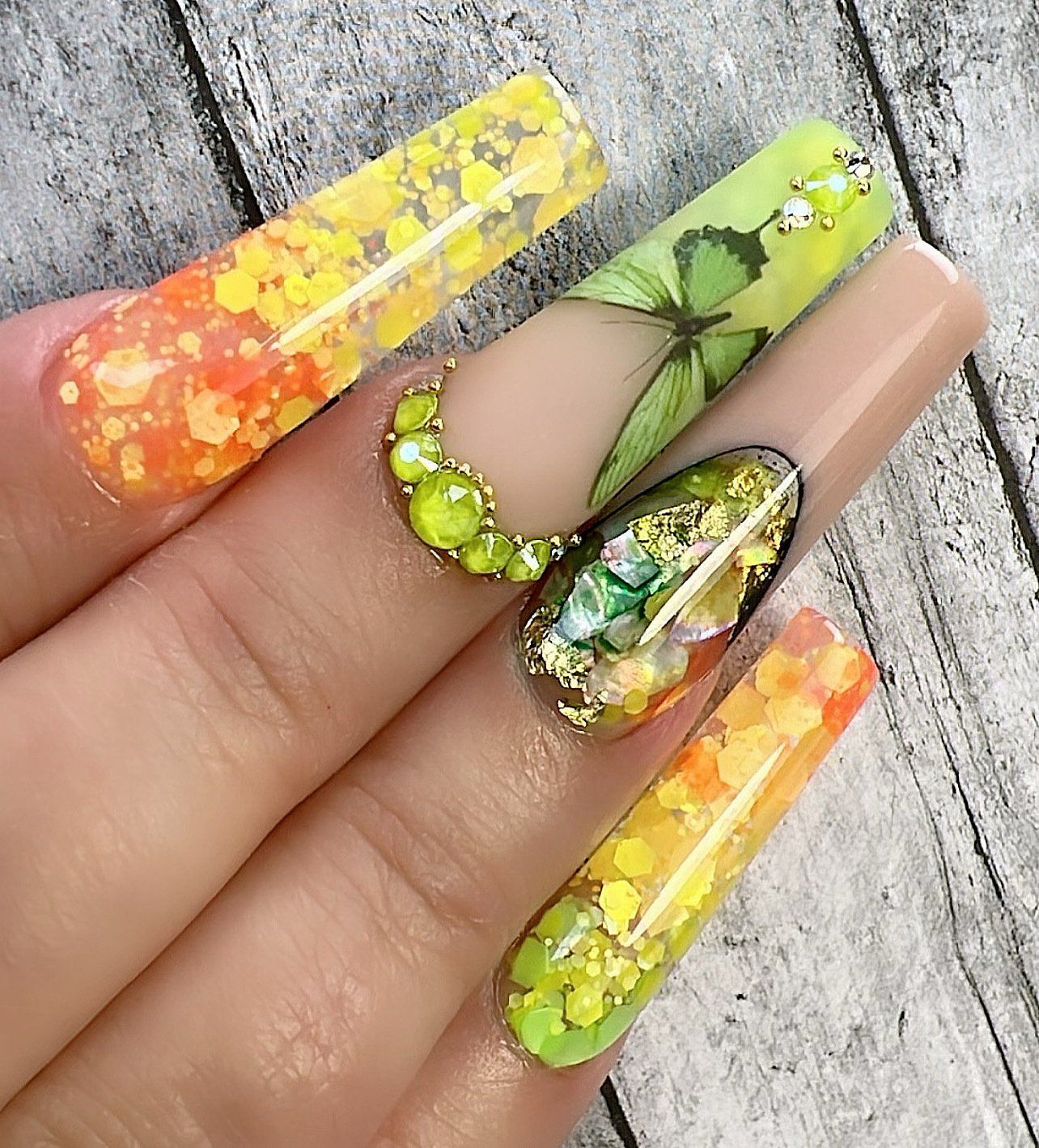 A close up of a person 's nails with a butterfly design on them.