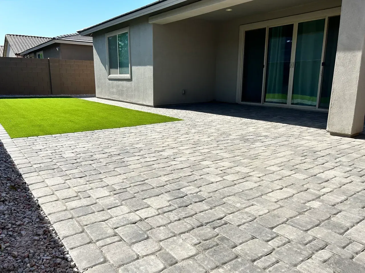 A house with a patio and a lawn in front of it.