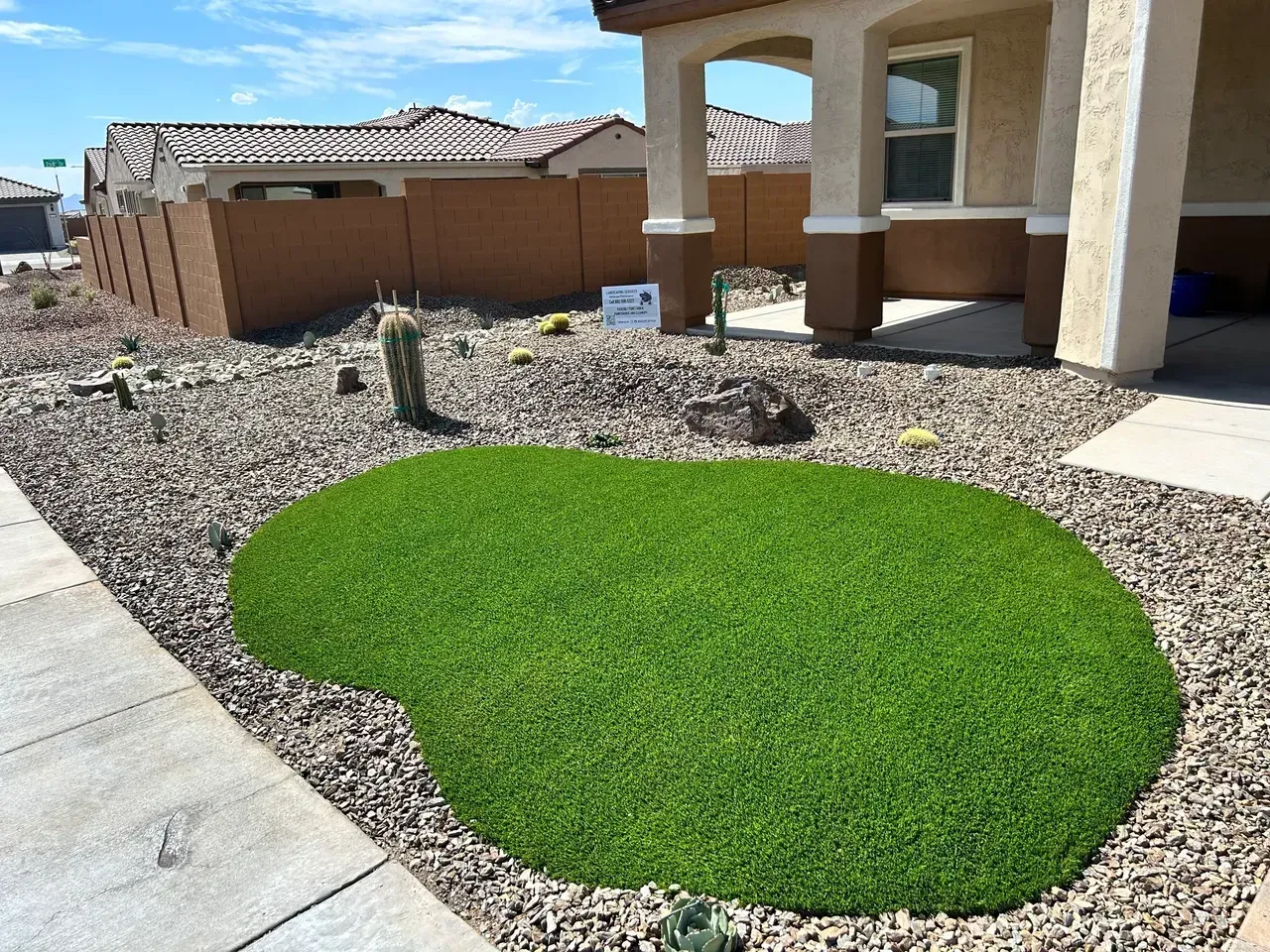 A lawn with a heart shaped patch of grass in front of a house.