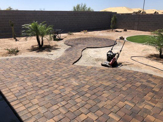 A lawn mower is sitting on top of a brick patio.