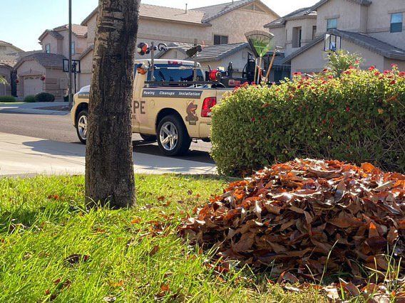 A tow truck is parked next to a pile of leaves