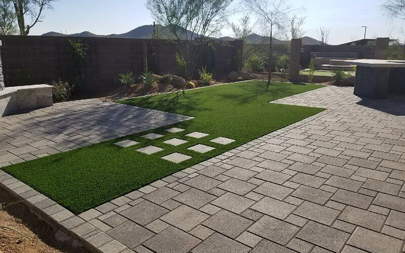 A patio with a lawn and a brick walkway.
