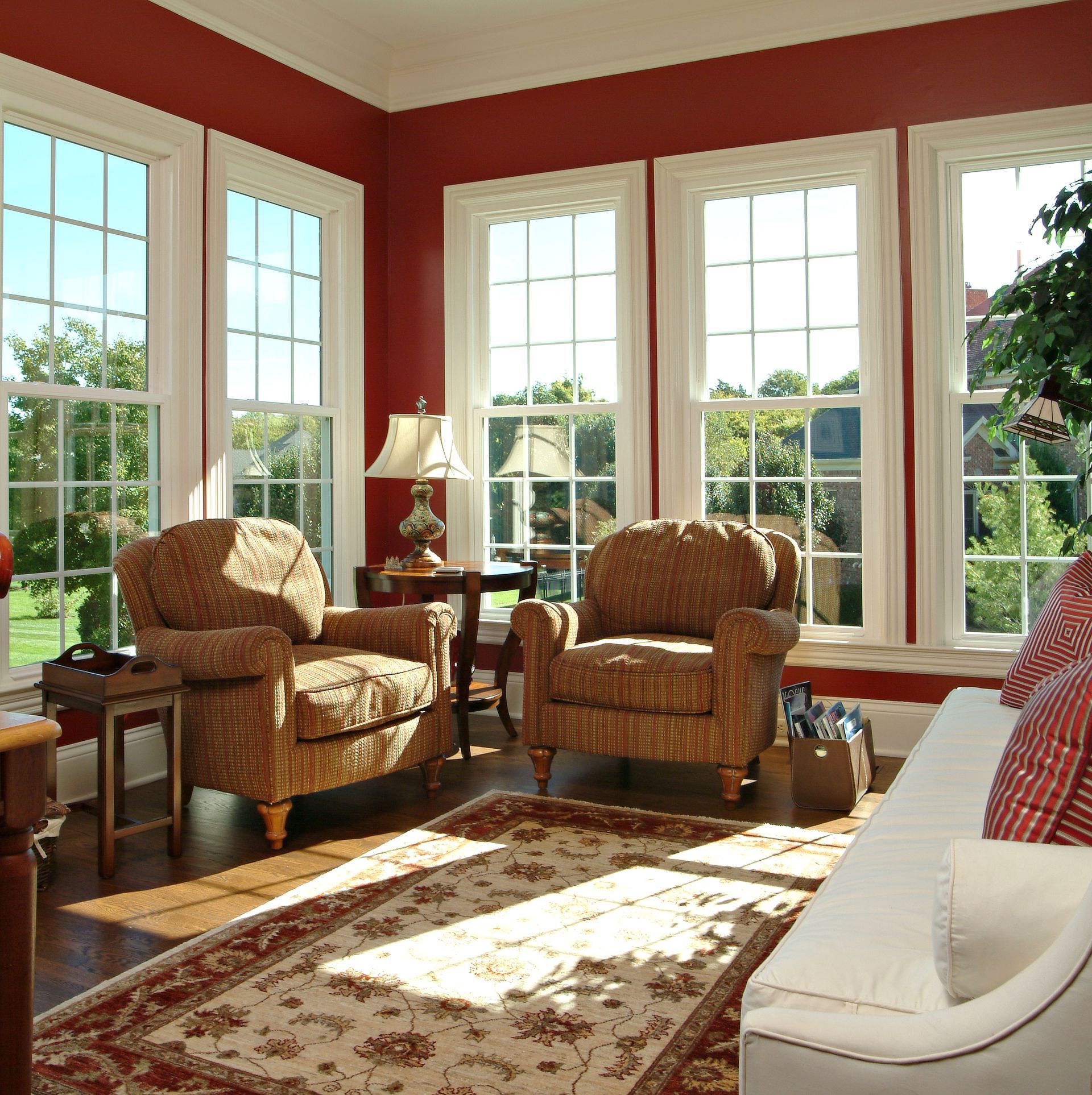 A living room with red walls and lots of windows