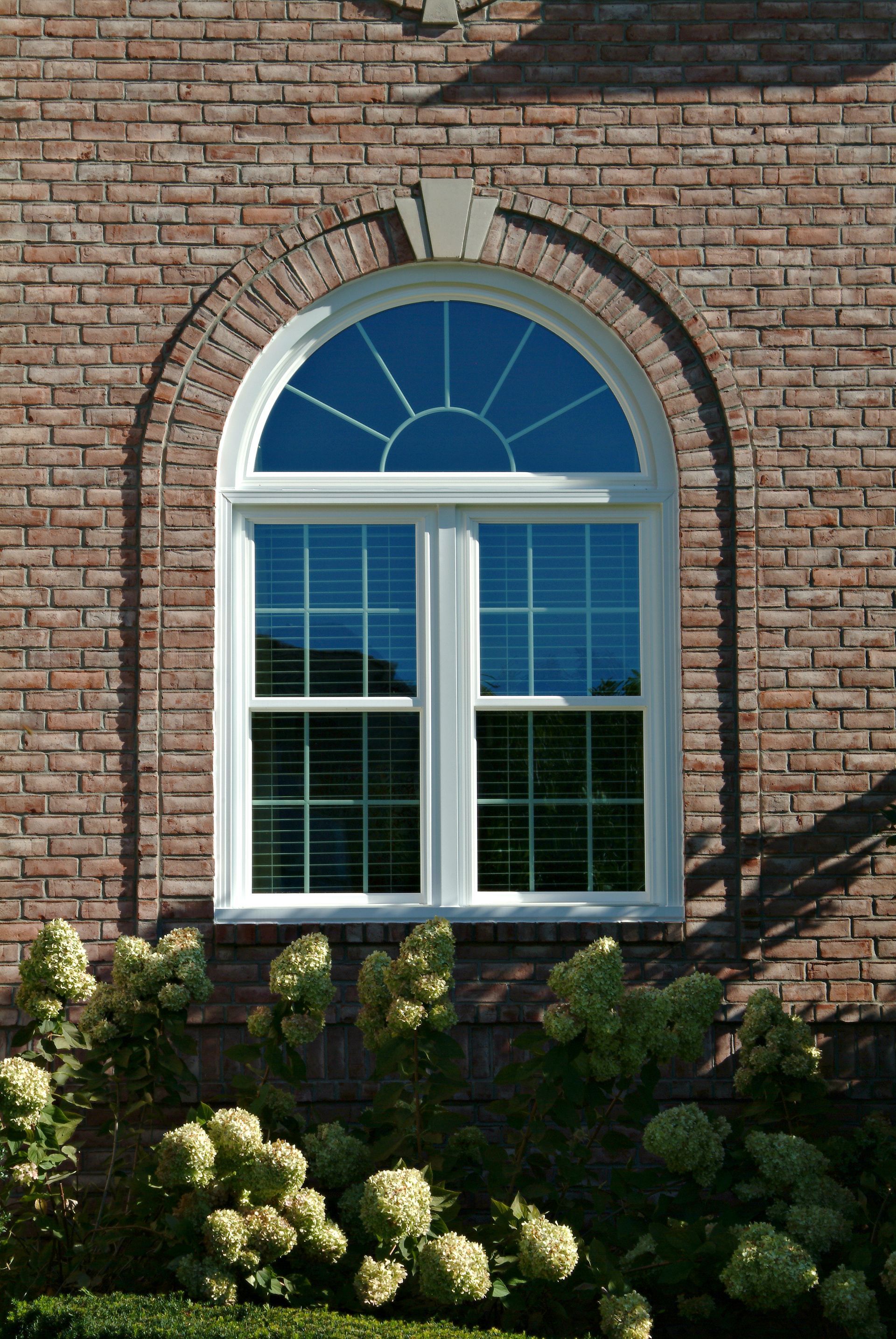 A large arched window on a brick building