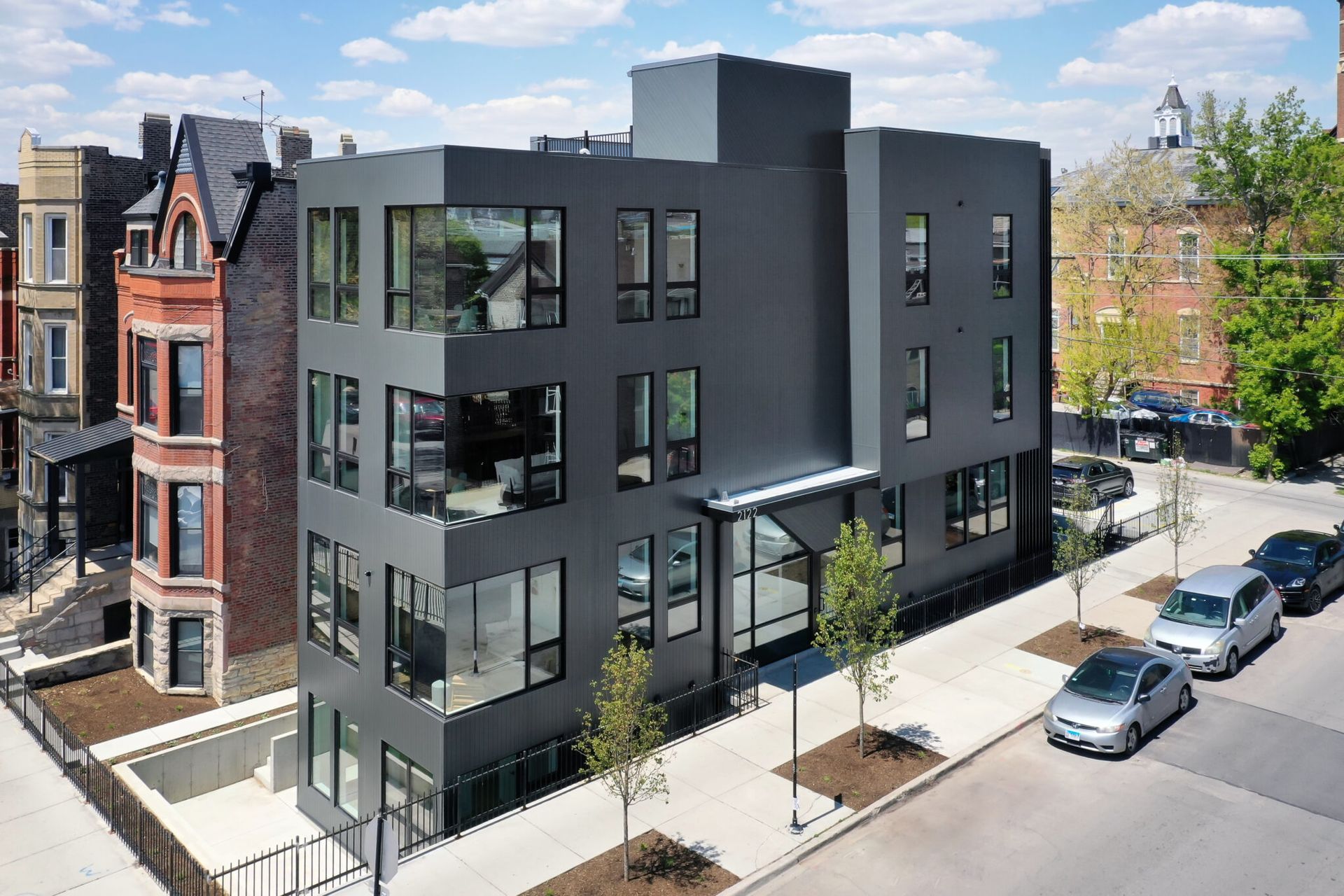 Modern grey building with large windows on a city street.