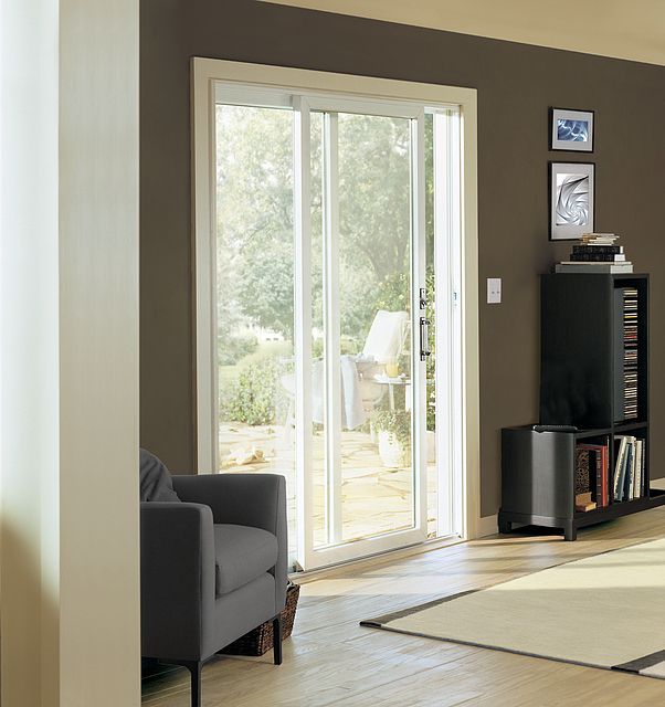 A living room with a sliding glass door and a chair