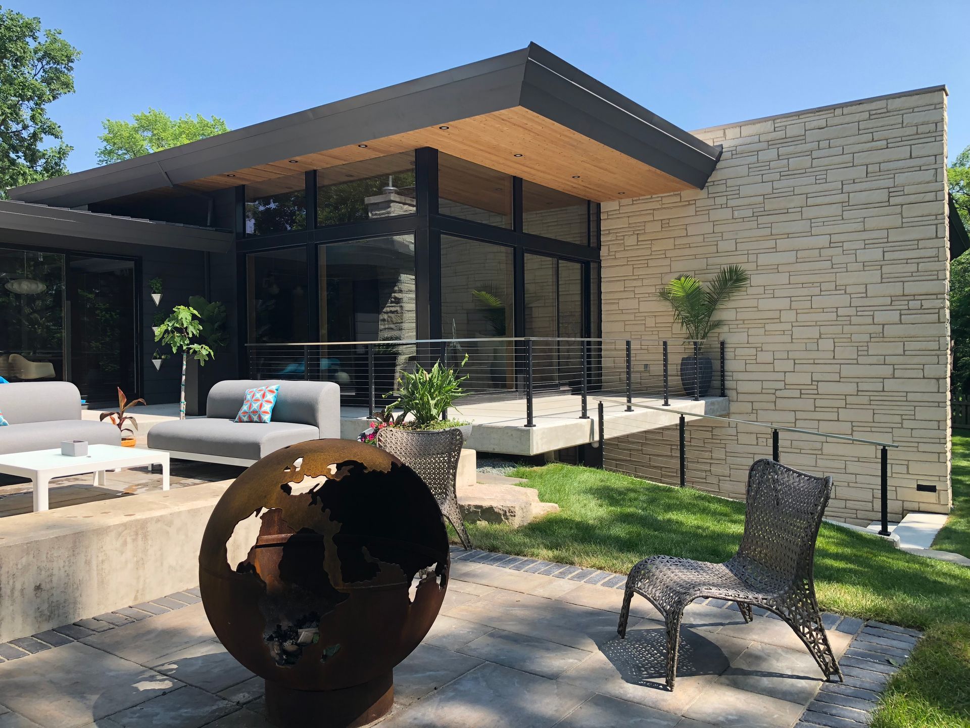 A modern house with a patio area and a fire pit in front of it.